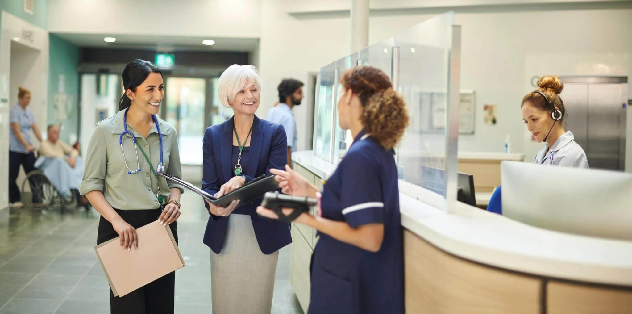 Healthcare professionals conversing in hospital lobby.