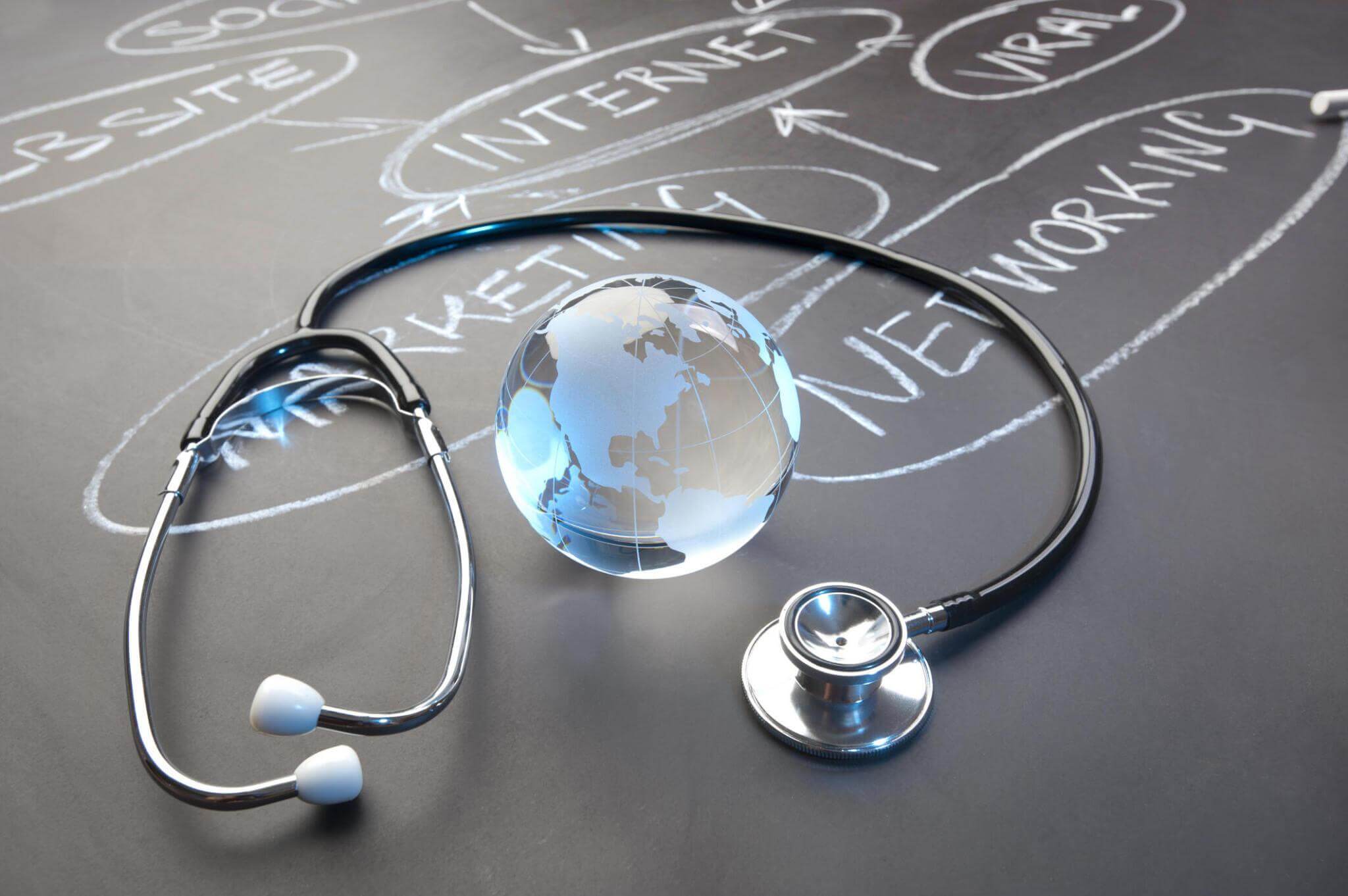 Stethoscope, globe, healthcare and technology concepts on chalkboard.