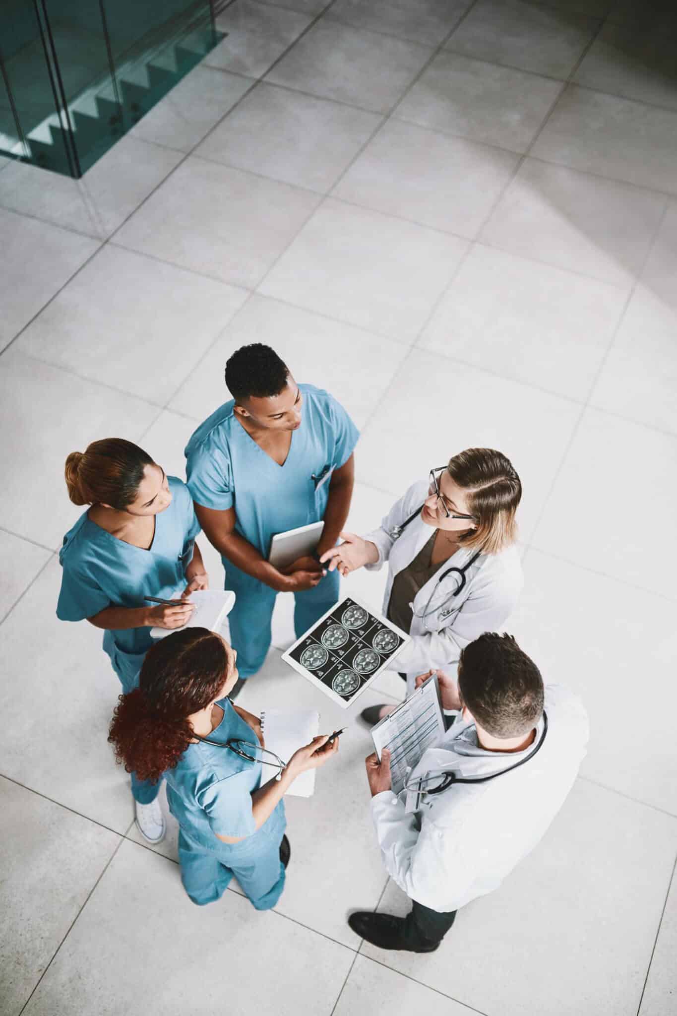 Medical team discussing patient's MRI scans in hospital.