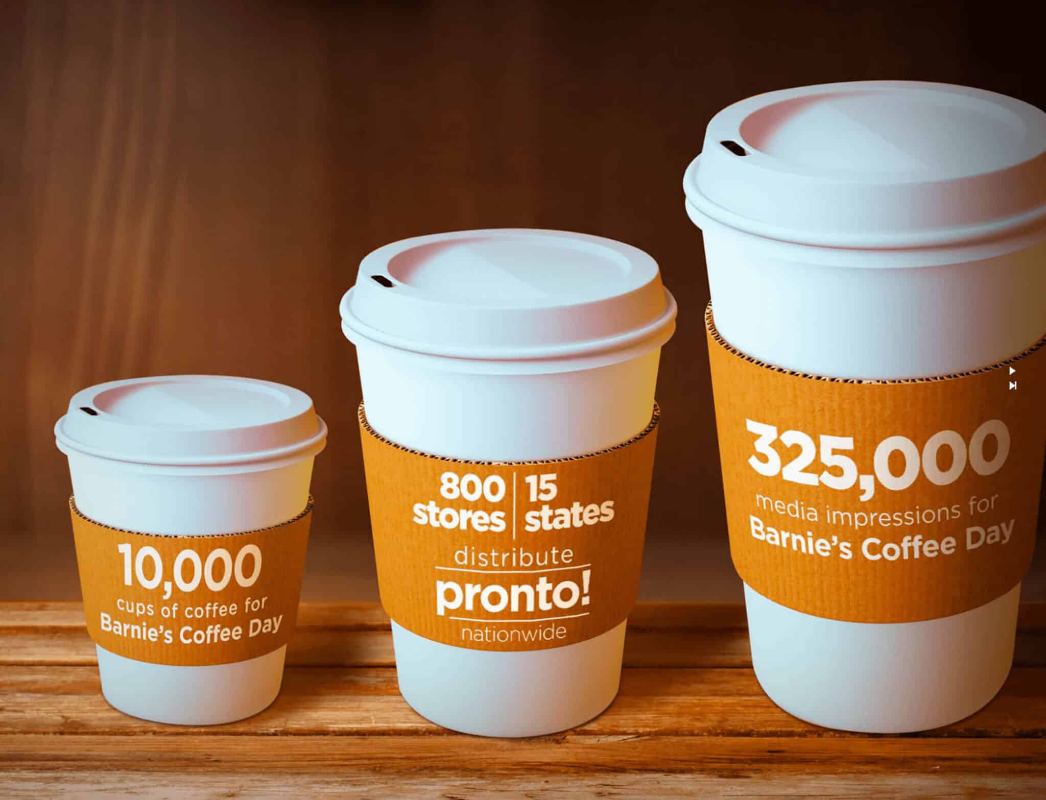Three branded coffee cups on wooden surface.