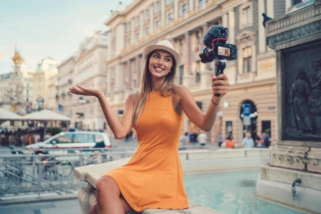 Woman vlogging in bustling city square.