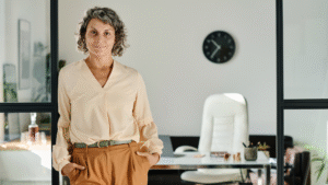 Confident person standing in modern office setting.