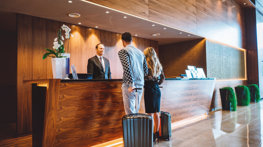 Couple checking in at hotel reception desk.