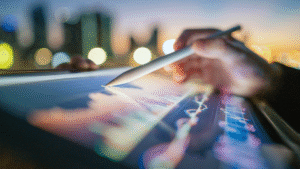 Hand using stylus on digital tablet with graphs