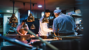Chefs preparing food in a busy restaurant kitchen.